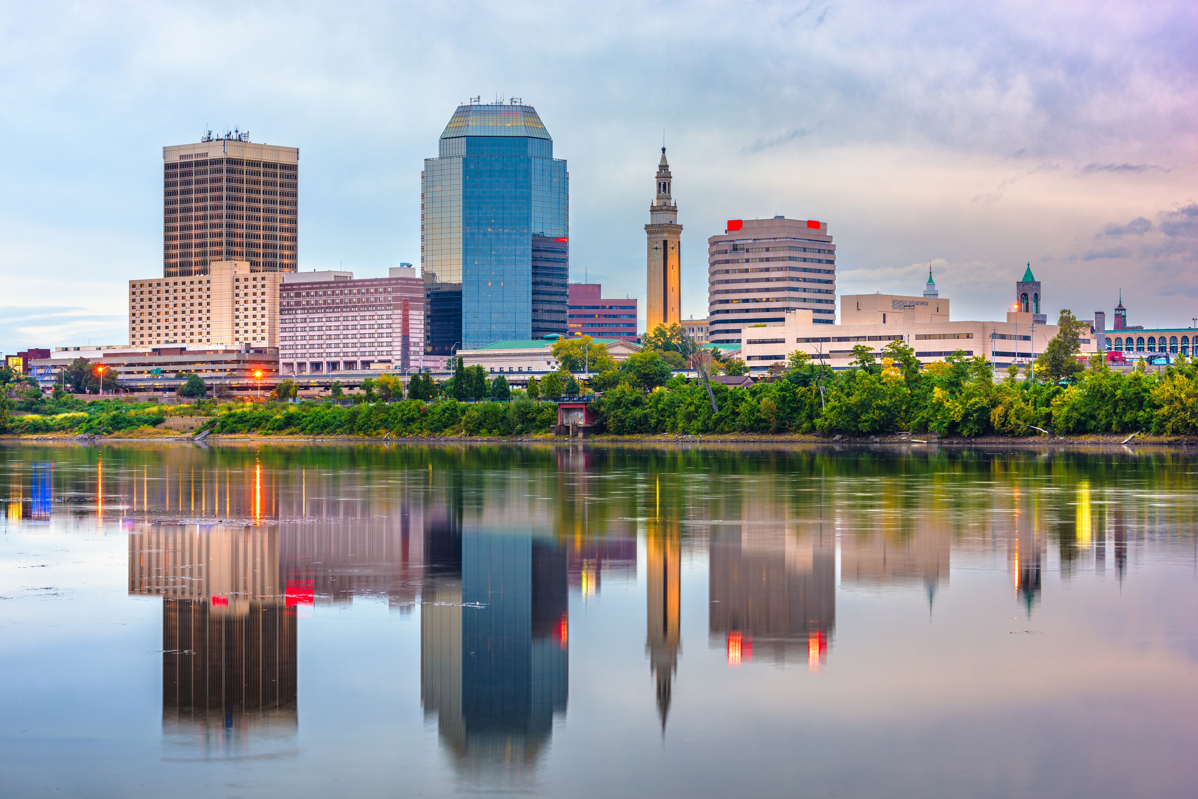 Skyline of Springfield, Massachusetts, reflected in the still waters of the Connecticut River during a calm evening.