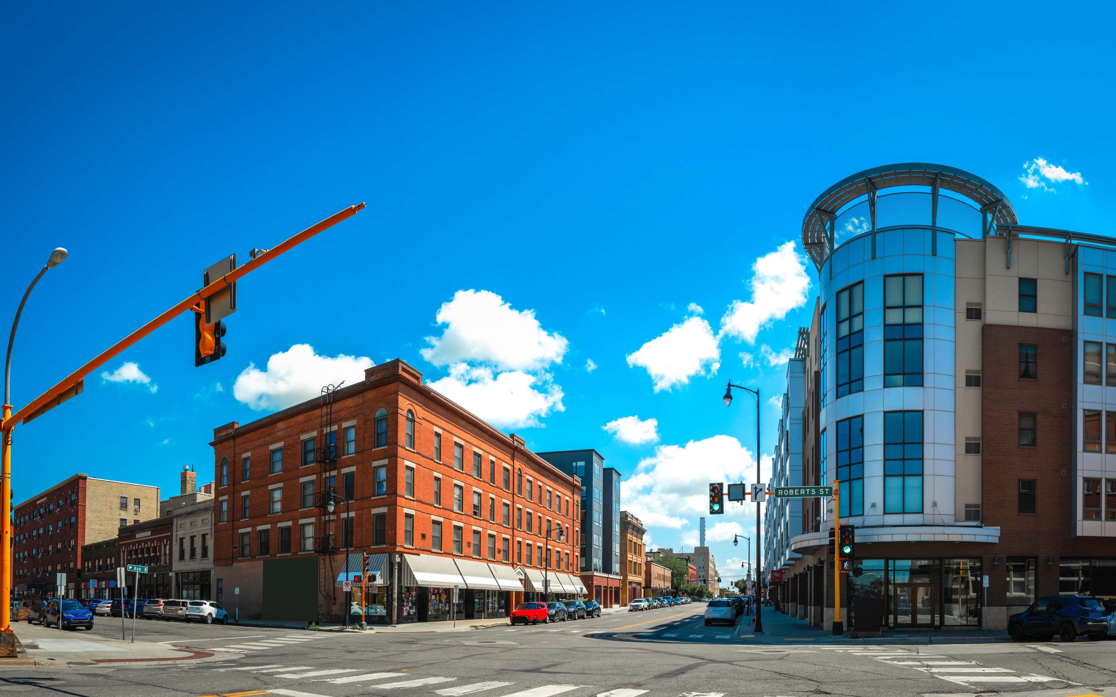 Downtown city intersection with mixed-use commercial buildings and traffic signals, representing local business districts and service coverage areas for records management and shredding services.