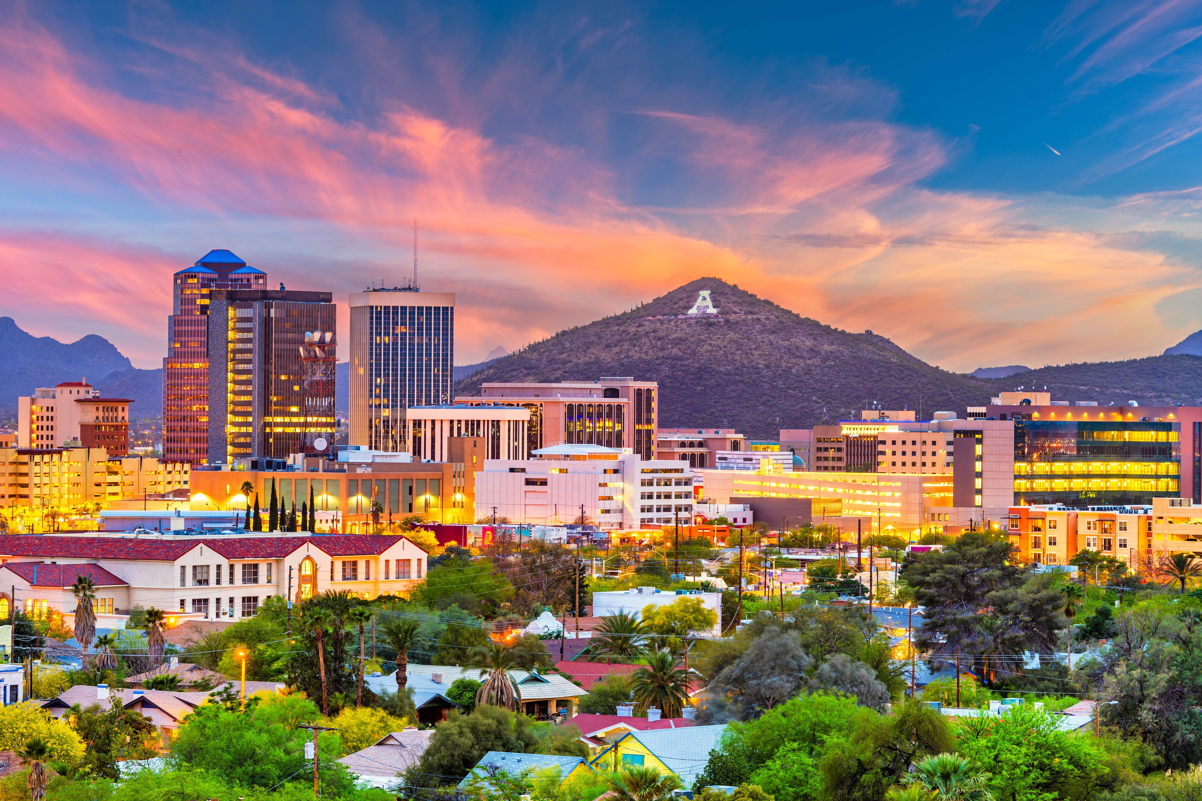 Colorful sunset over the Tucson, Arizona skyline with downtown buildings in front of Sentinel Peak, marked by the iconic white “A.”