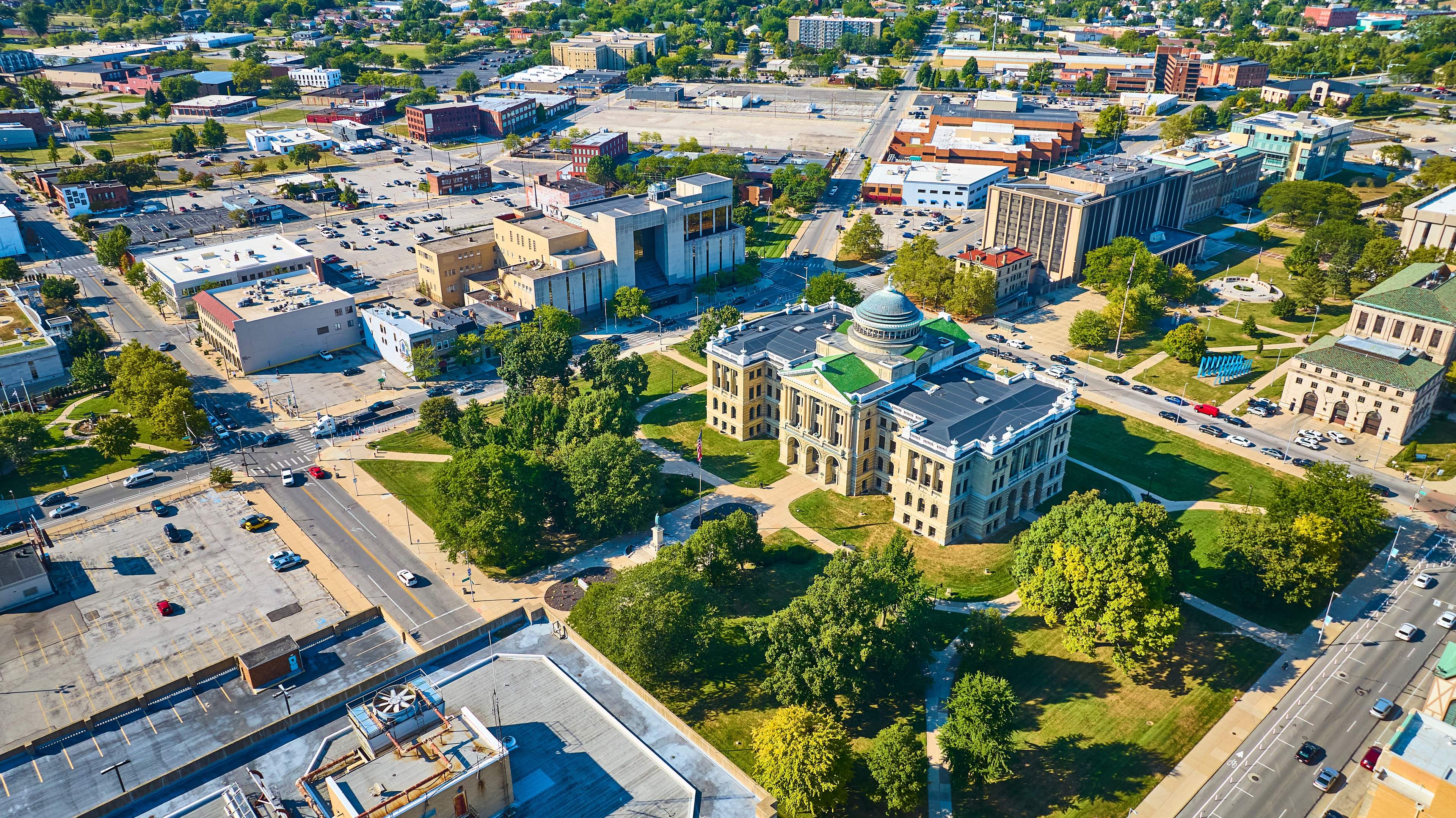 Aerial view of downtown Toledo, Ohio, highlighting historic architecture, civic buildings, and tree-lined streets on a clear summer day.