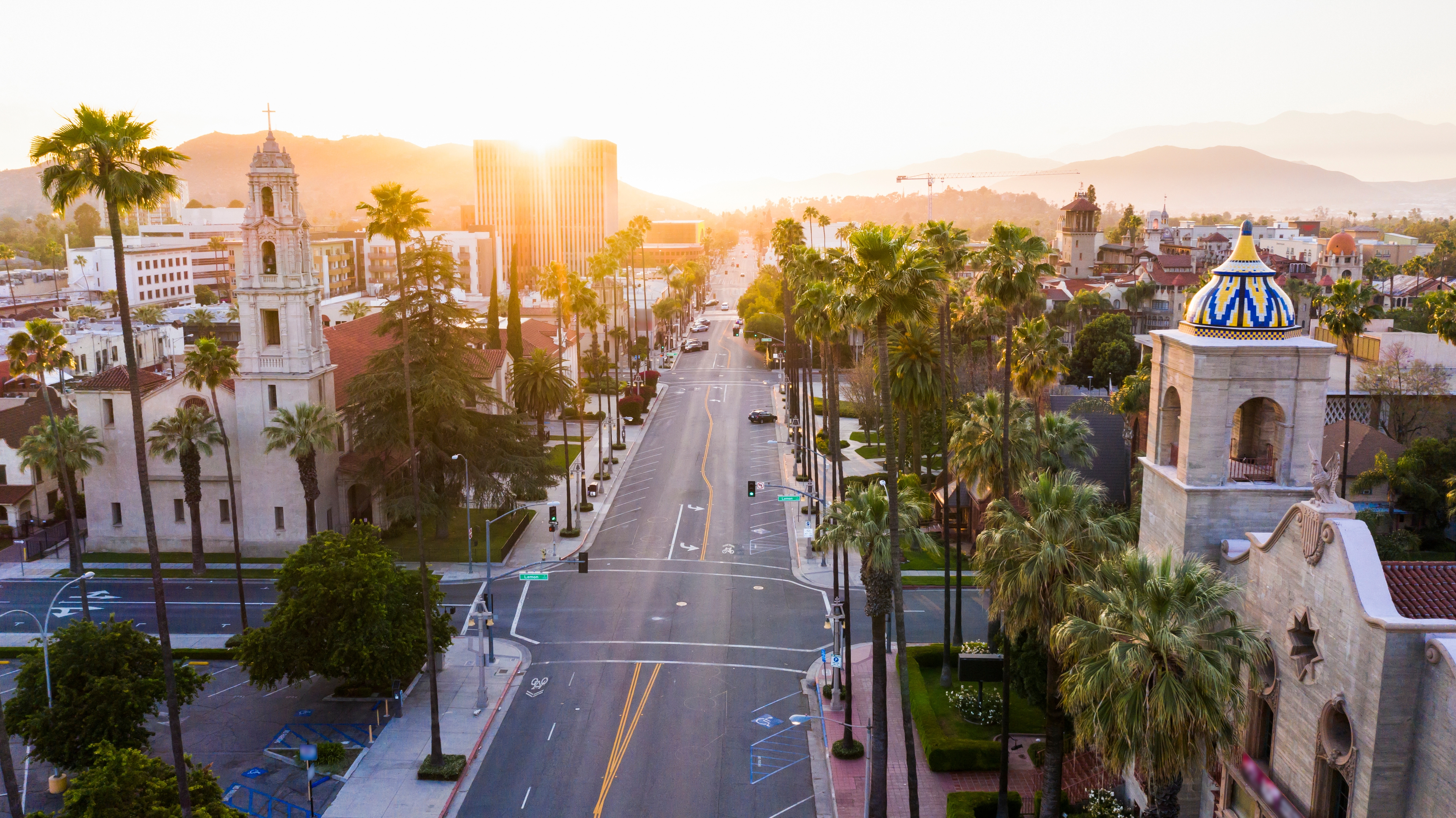 Sunrise over downtown Riverside, CA, showcasing Spanish-style architecture, palm-lined streets, and a peaceful cityscape.
