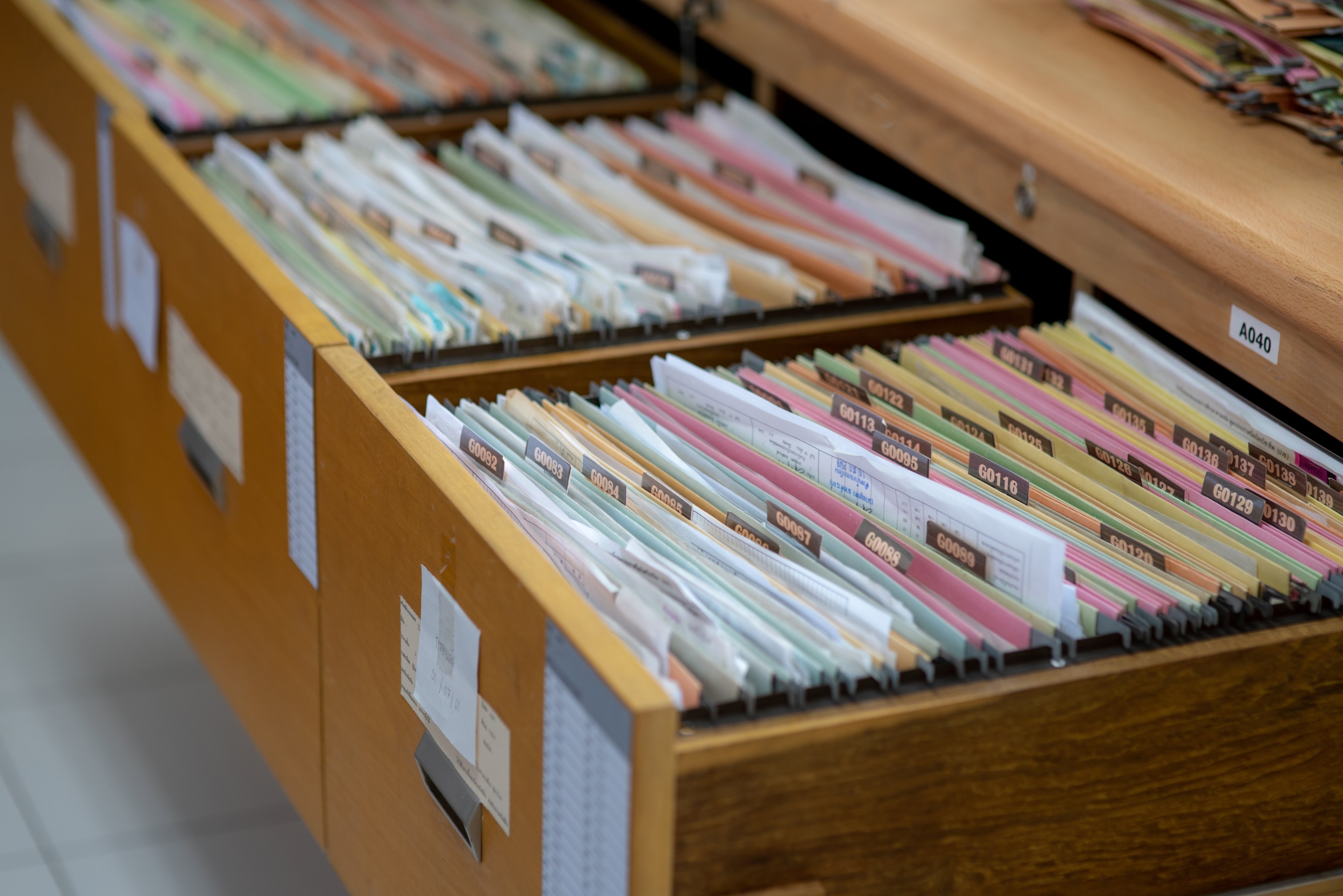 Close-up of open filing cabinet drawers filled with organized documents and folders, showcasing efficient record-keeping.