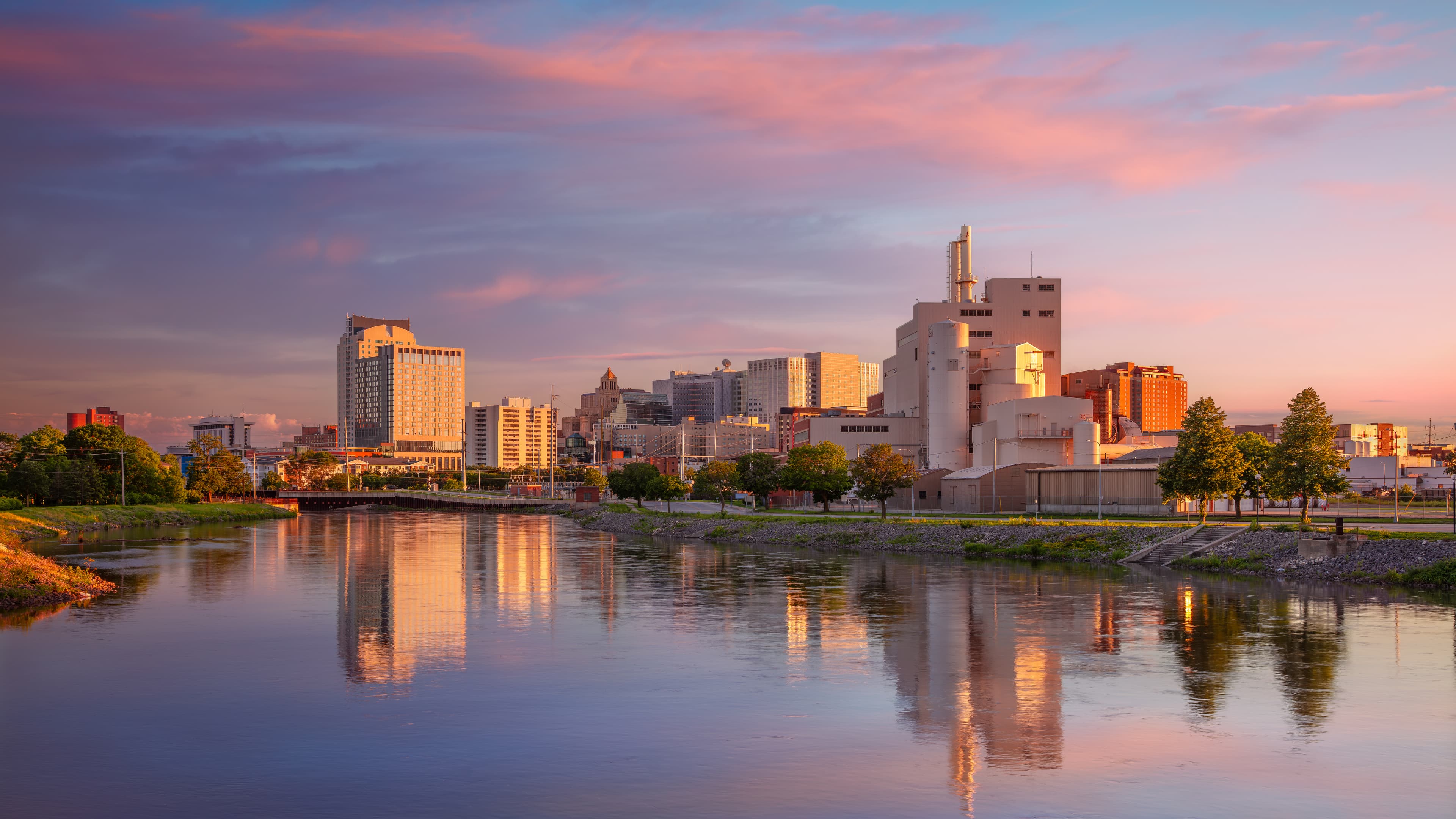 Downtown Rochester, Minnesota skyline at sunset along the Zumbro River, representing local records management, storage, and shredding service coverage in the Rochester market.