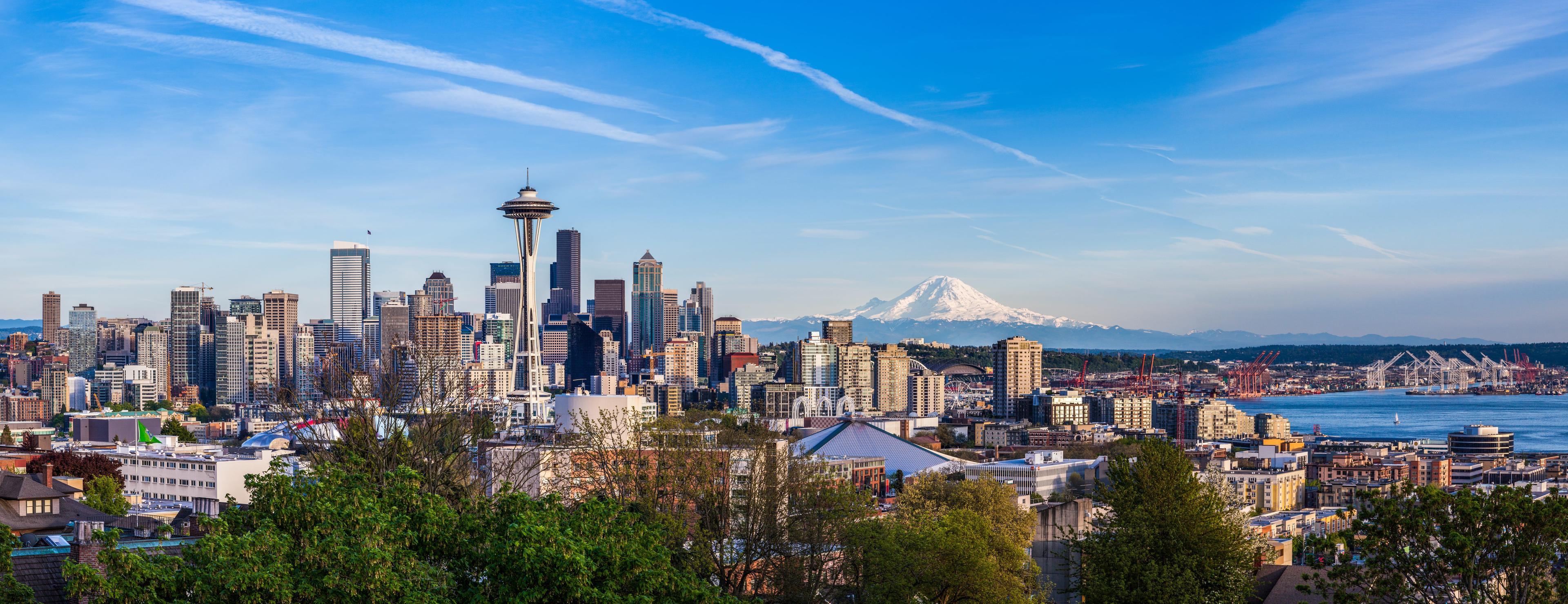 Panoramic view of Seattle’s skyline with the iconic Space Needle, downtown skyscrapers, and Mount Rainier in the background on a clear day.