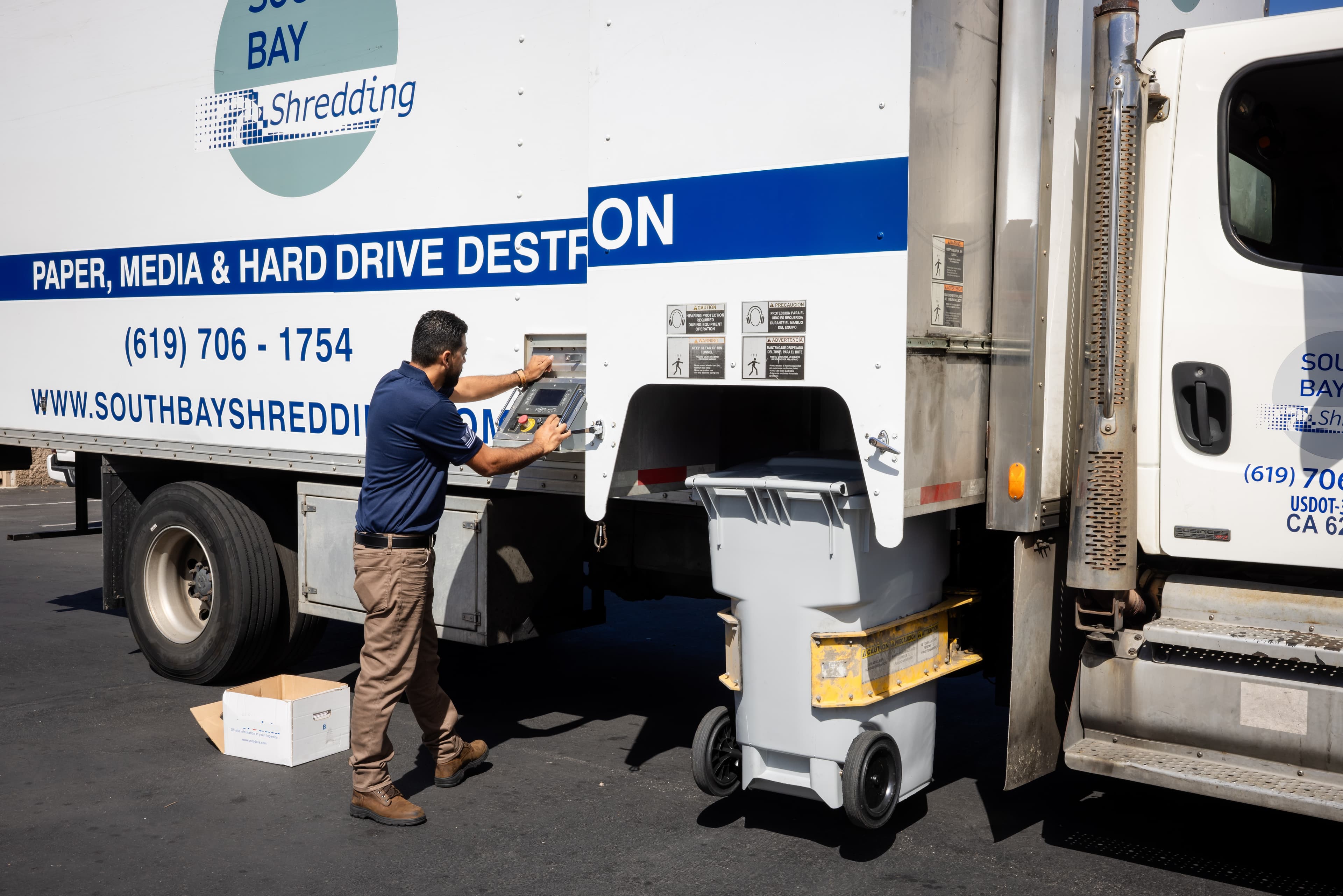 On-site mobile shredding truck with technician securely destroying paper and hard drives, representing compliant document destruction and secure records disposal services.