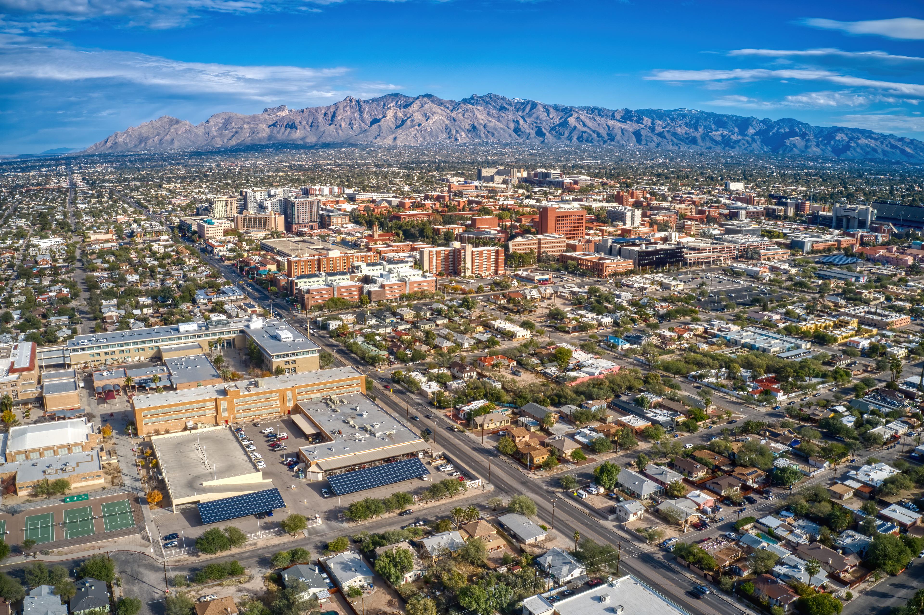 Aerial view of Tucson, Arizona featuring the University of Arizona campus and surrounding neighborhoods with the Santa Catalina Mountains in the background.