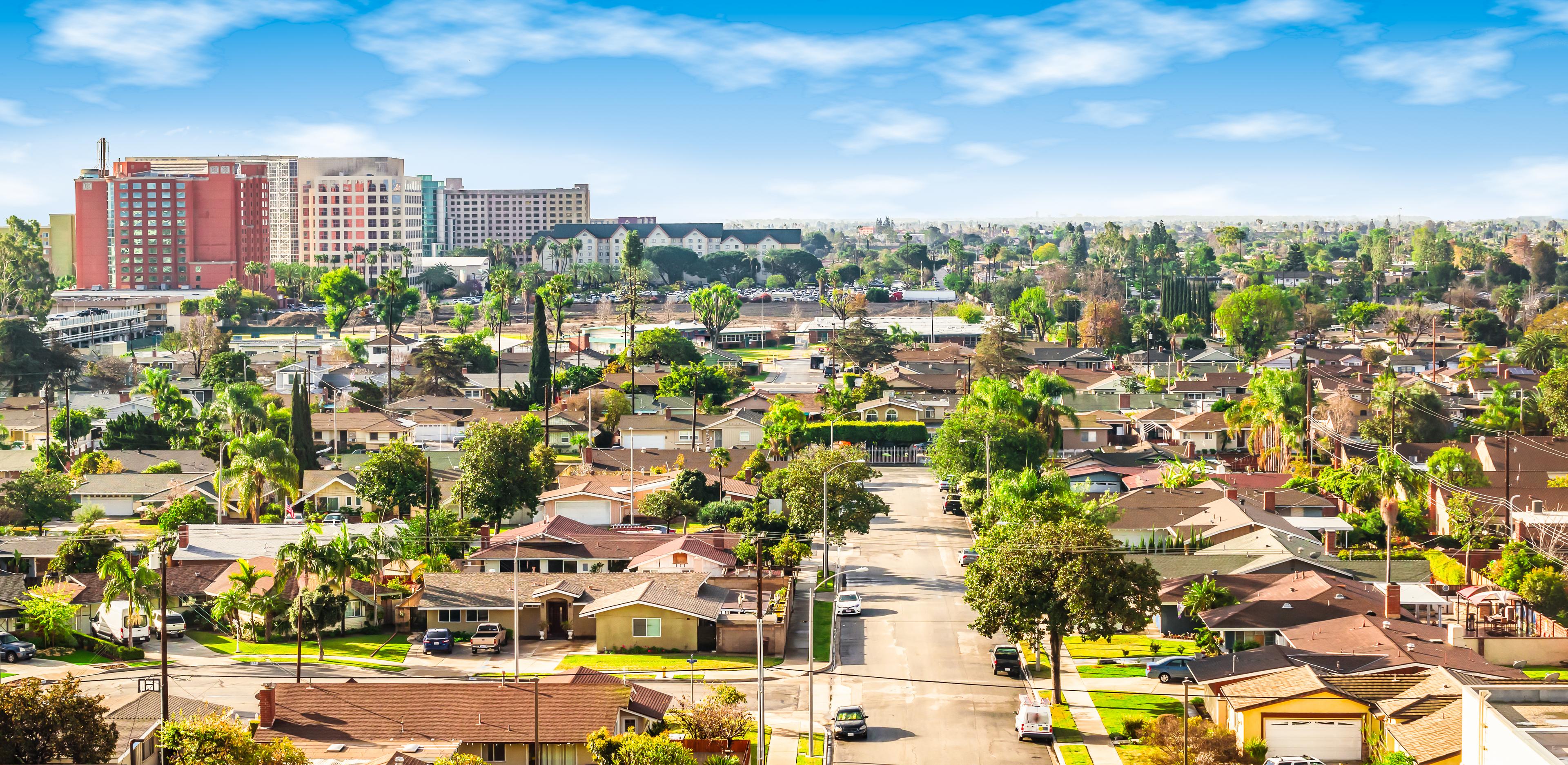 Aerial view of Anaheim, California, showcasing a mix of residential neighborhoods and high-rise buildings near the Disneyland Resort area.

