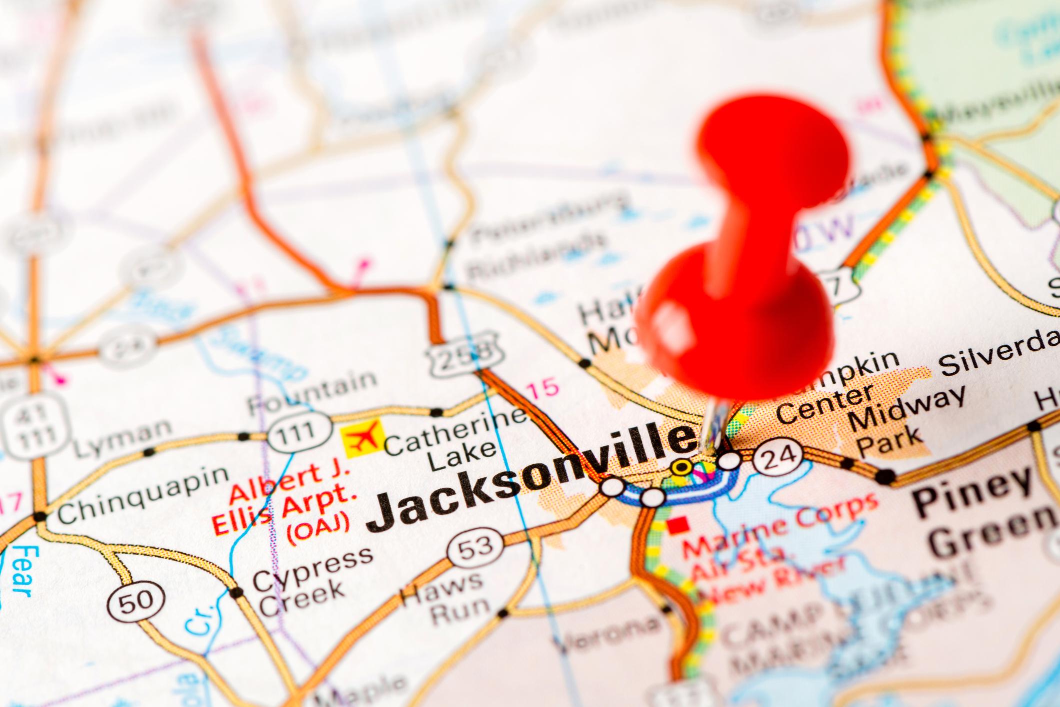 A detailed map highlighting Jacksonville, North Carolina, with a red pushpin, showing nearby roads, landmarks, and military bases
