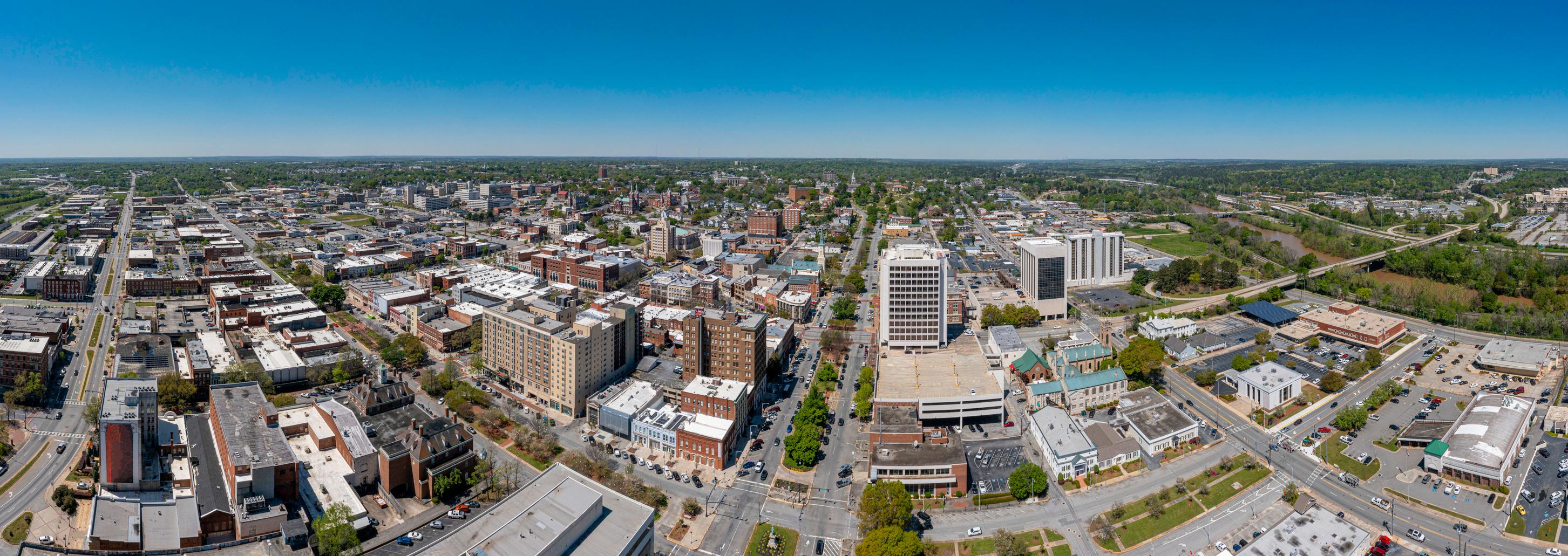Wide-angle aerial view of downtown Macon, Georgia, showcasing its historic architecture, business district, and Ocmulgee River.