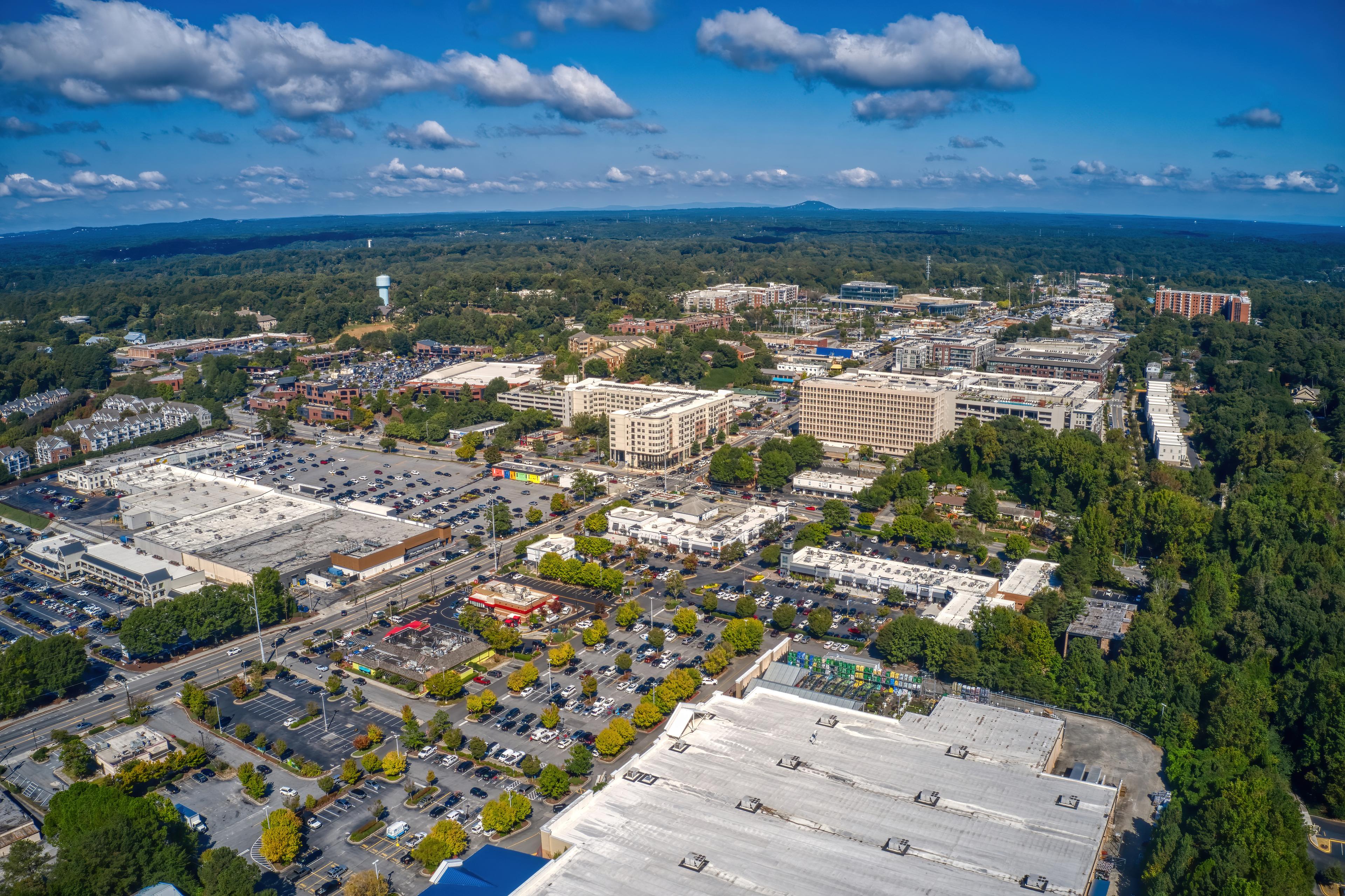 Aerial view of Sandy Springs, Georgia, showcasing urban development, retail centers, and green landscapes.
